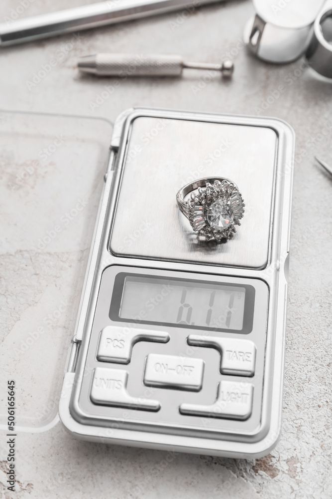 Jewelry scales with ring on light background