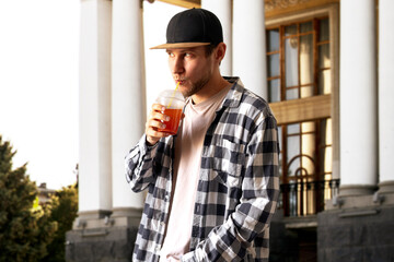 Wall Mural - young person holding fresh cold summer cocktail with a straw