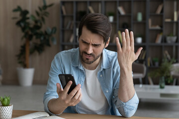 Wall Mural - telephone problem. upset angry millennial male feel outraged by bad wrong work of smartphone app poo