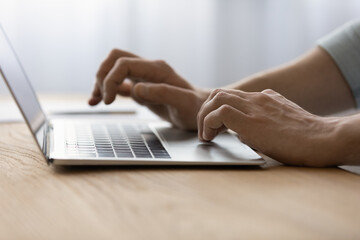Wall Mural - using laptop. close up of young man employee office worker student freelancer hands typing on modern
