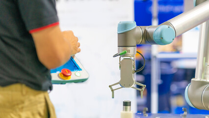 cobot(collaborative robot) with gripper are being programmed by trainning engineer in automation lab