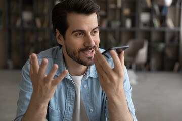 Wall Mural - voice application. happy millennial male hold mobile phone talk using digital voice recorder dictate