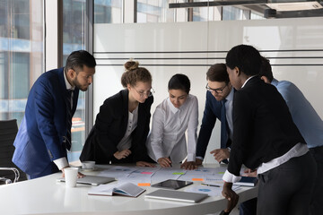 Canvas Print - Multi racial company management, staff members cooperate together gather in boardroom at briefing, discuss business ideas, search solution, review sales results engaged in teamwork, brainstorm concept