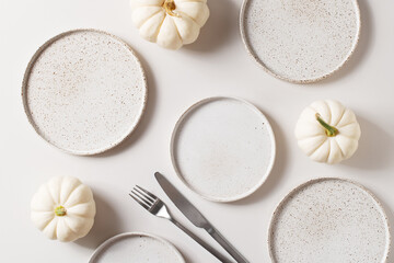 Wall Mural - Some white ceramic plates with tableware and pumpkins serving background