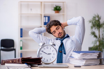 Wall Mural - Young male employee in oversleeping concept