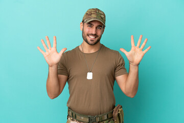 Canvas Print - Military with dog tag over isolated on blue background counting ten with fingers