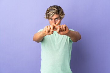 English man over isolated purple background making stop gesture with her hand to stop an act