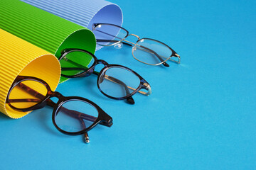 Sticker - rolls of corrugated cardboard and several pairs of stylish glasses, eyeglass frames in the fashion trend