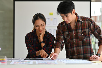 Wall Mural - young creative asian woman and man ux ui designer planning to create smartphone application..website