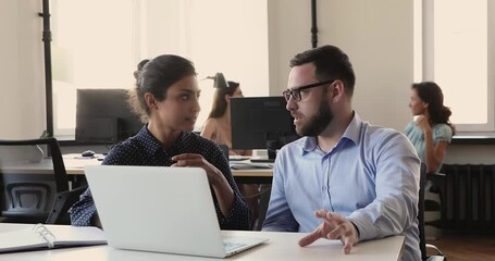 Canvas Print - Focused businessman sales manager insurance agent consult young Indian woman client discuss deal details propose new solution. Two colleagues of different ethnicity gender talk brainstorm on workplace