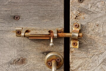 Canvas Print - one old gray metal closed latch in brown rust on a wooden door and wall