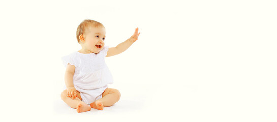 cute baby looking up sitting on the floor greeting waving his hand on white background, banner blank