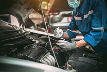 Car Care Maintenance And Servicing, Close-up Hand Technician Auto Mechanic Checking Inspection List After Repairing Change Spare Part Car Engine Problem And Car Insurance Service.