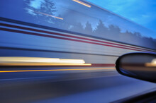 A Blurred Image Of A Large Bus From A Car Window Due To Speed. The Vehicle Was Moving Towards The Highway At High Speed.