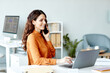 © Seventyfour - Young adult Caucasian businesswoman sitting at desk in modern office working with documents using laptop and talking on phone