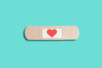 medical patch with red heart on blue background. abstract love concept, healing patch, broken love