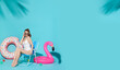 Happy woman chilling in lounge chair near flamingo rubber ring on blue copy space background. woman relaxing on beach in summer holiday.