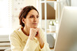 © Seventyfour - Pensive young adult woman wearing cream beige shirt working in office watching presentation or video on computer