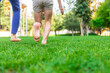 © yanadjan - Children's feet go on the grass. Selective focus.