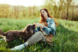Woman happily smiling at playing with her little dog outdoors on fresh green grass in the summer sunshine her and her dog's health, Health Concept and timely treatment for insects ticks and tick fleas
