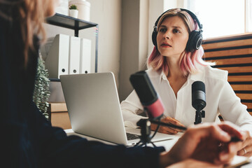 Wall Mural - Two woman hosts in local broadcat studio recording audio podcast