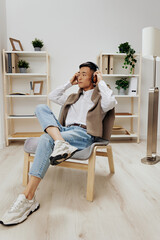 man in headphones sits on a chair rest music Lifestyle