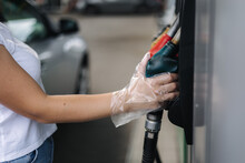 Close-up Of A Women's Hand Using A Fuel Nozzle At A Gas Station. Petrol Station Concept. Filling Station At Petrol Gasoline. Fuel Shortage In Ukraine