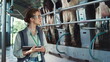 © stockbusters - Dairy farm worker control automatic milking process at modern farm facility.