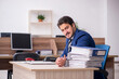© Elnur - Young male employee and too much work in the office