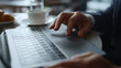 © stockbusters - Man hands working computer online using touchpad browsing business news in cafe.