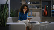 © stockbusters - Smiling freelancer woman working tablet talking mobile phone at home office.