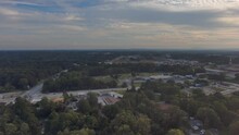 Aerial Footage Of Vast Miles Of Lush Green Trees With Buildings Nestled Into The Trees With Blue Sky And Clouds At Sunset At Rhodes Jordan Park In Lawrenceville Georgia USA
