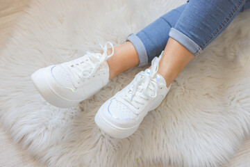 Woman wearing comfortable stylish sneakers indoors, closeup