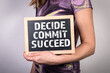 DECIDE COMMIT SUCCEED. Chalk board in a woman's hands