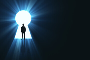 Wall Mural - backlit businessman standing in bright keyhole opening on dark background with mock up place and lig