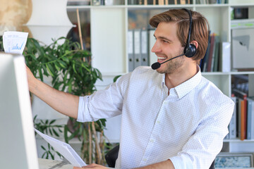 Sticker - Cheerful young support phone male operator in headset, at workplace while using computer