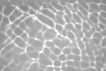 Blurred defocused water texture overlay effect for photo and mockups. Organic drop diagonal shadow and light caustic effect on a white wall. Shadows for natural light effects