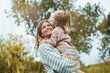 © Westend61 - Happy mother embracing daughter in meadow