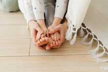 Mother's Hand Holding Daughter's Feet At Home