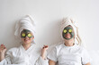 © Westend61 - Happy young friends wearing facial masks relaxing at home