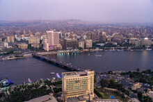 Egypt, Cairo, River Nile, Qasr El Nil Bridge And Surrounding Buildings Of Gezira And Garden City At Dusk
