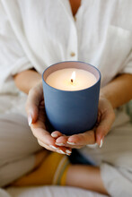 Hands Of Woman Holding Scented Candle At Home