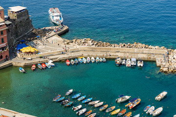 Wall Mural - Aerial view of the small port of the ancient Vernazza village with small boats moored and the ferry station. Cinque Terre National park in Liguria, La Spezia, Italy, Europe. UNESCO world heritage site