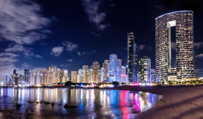 Dubai jumeirah beach with marina skyscrapers in UAE at night.