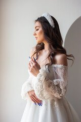 Full length portrait of young beautiful woman wearing white wedding dress. Elegant bride standing and posing