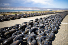 Chains For Ships Lies On The Pier Against The Background Of A Cloudy Sky And The Black Sea