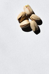 Sticker - top view of cracked and healthy pistachio nuts on white