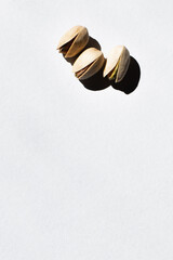 Sticker - top view of cracked and organic pistachio nuts on white