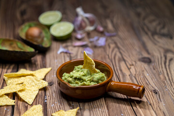 Wall Mural - avocado dip flavored with garlic, chili, pepper, and lime juice with corn nachos