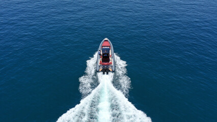 Wall Mural - Aerial drone photo of inflatable rigid power boat cruising in high speed in Aegean deep blue sea bay, Greece